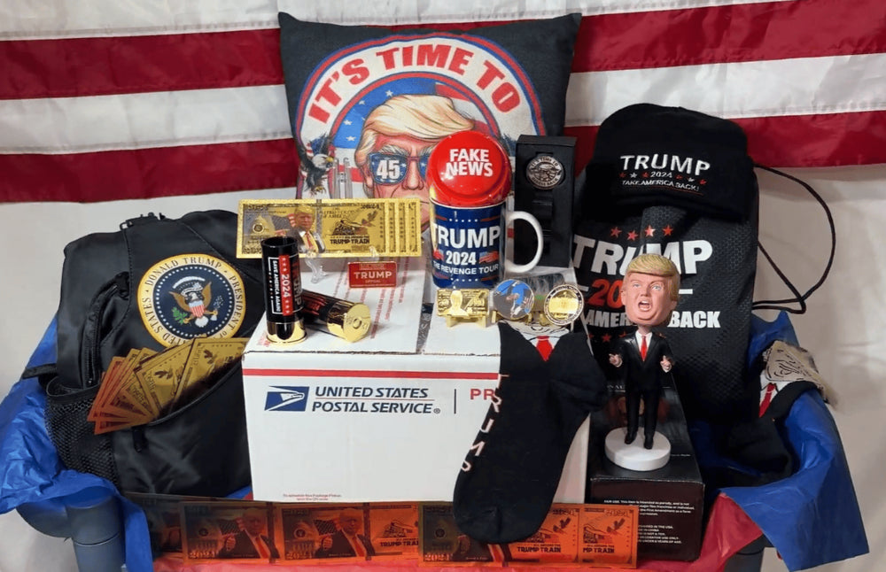 Trump Patriot Mystery Box shipment: USPS box surrounded by Trump hats, pillow, mug, bobblehead, gold bills and patriotic collectibles on an American flag
